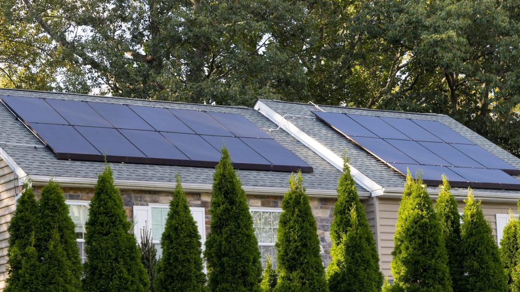 Several solar panels installed on the roof of a residence.
