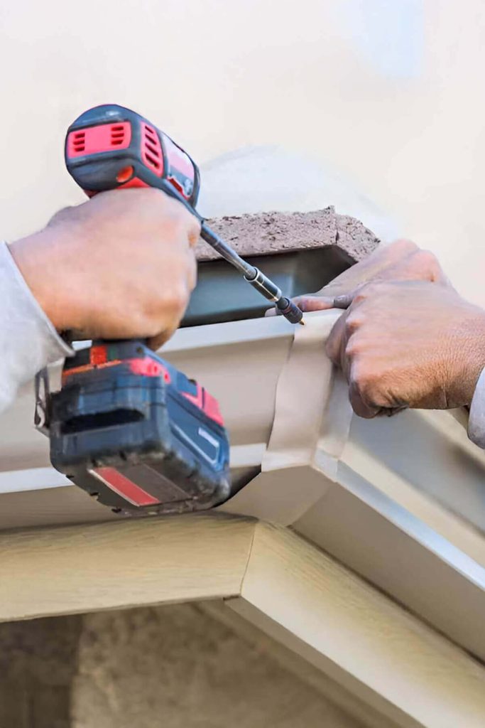Zoom in on workers hands doing gutter repair on residential home.