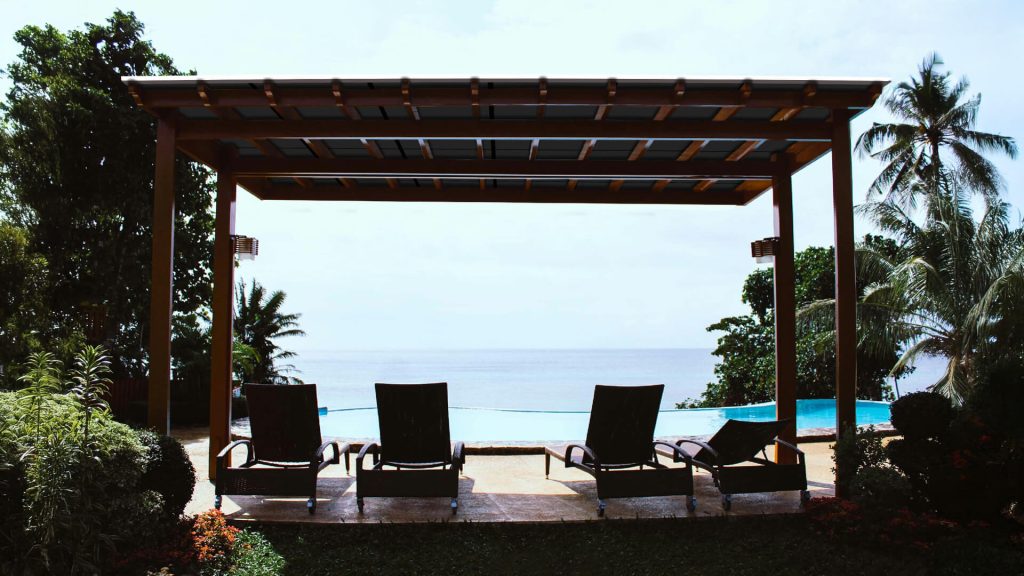 Pergola covered with solar panels by the pool on the coast.