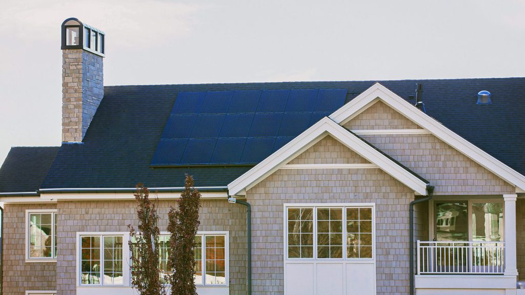 Set of solar panels installed on the roof of a large house.